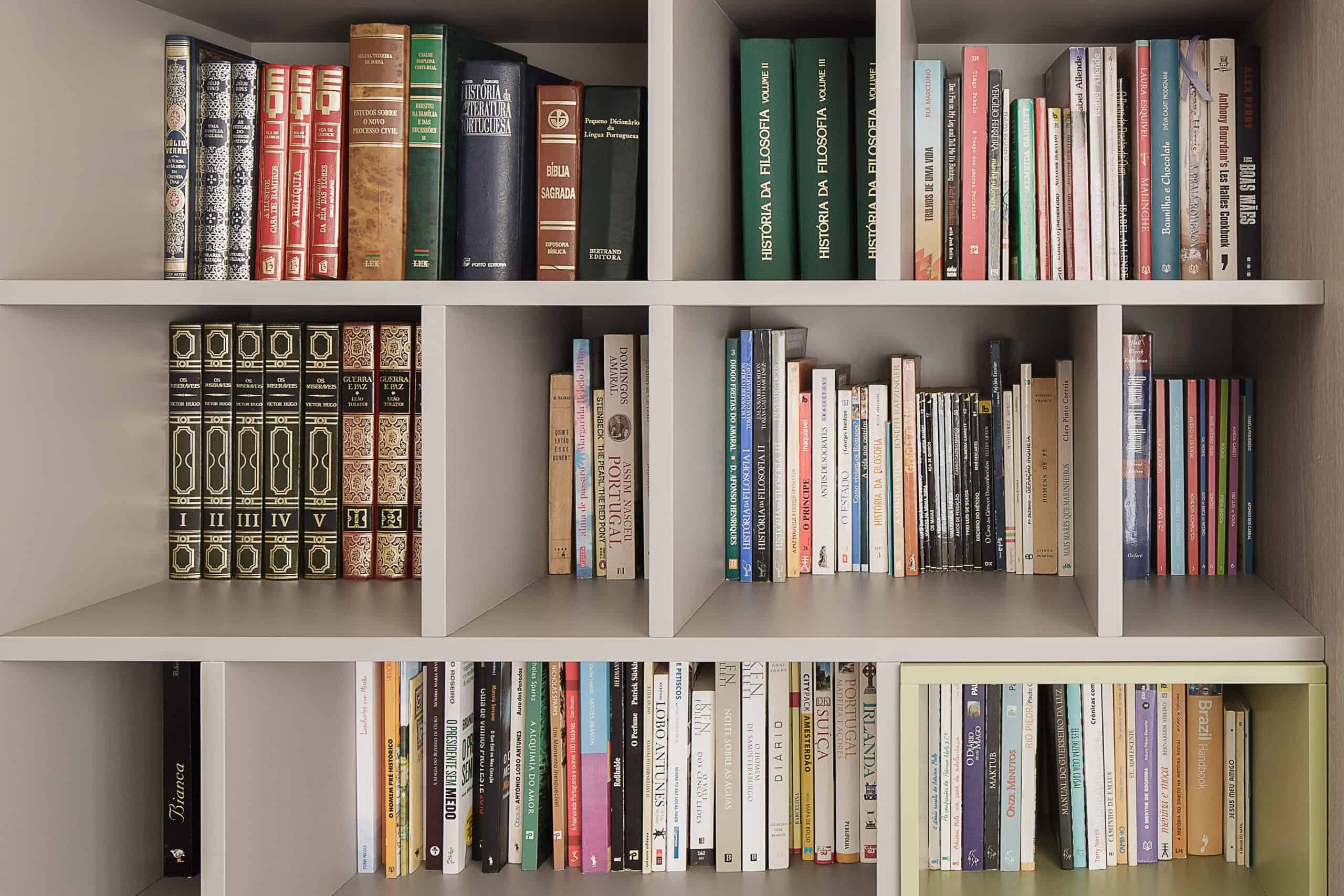 A well-organized bookshelf with an assortment of books arranged by size and color, featuring guest's book reviews.