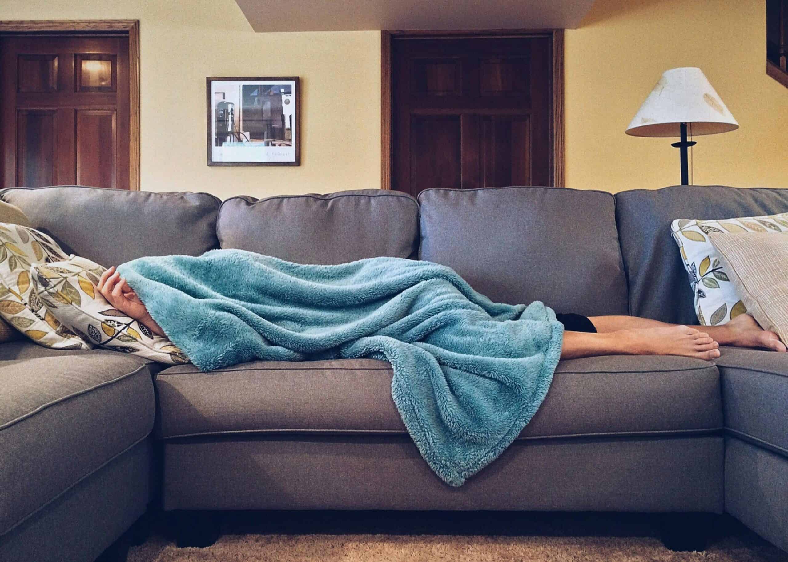 A person sleeping on a couch, dreaming of empowering their midlife through financial planning.