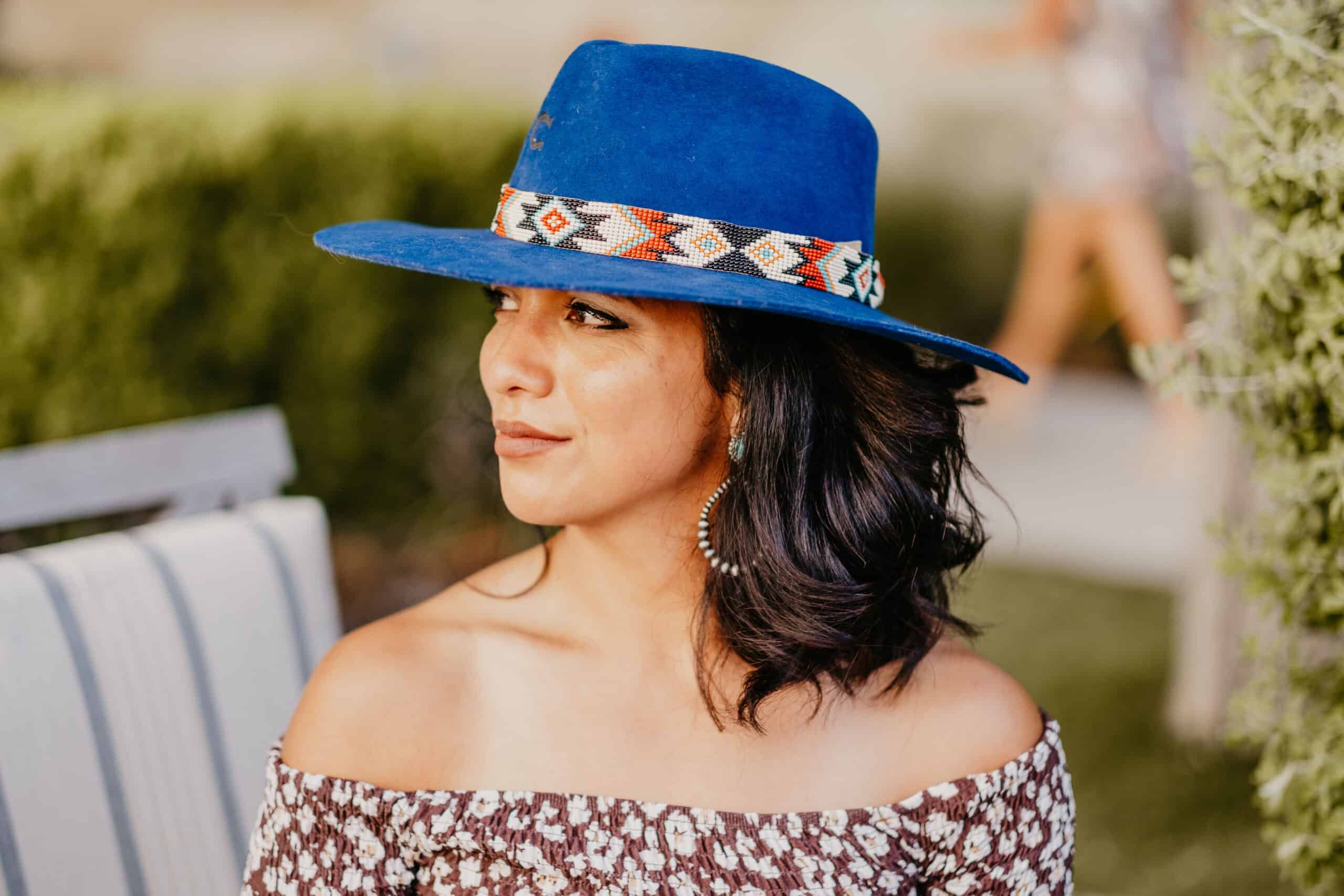 Susie Maldonado wearing a blue hat and floral top is an upcoming guest.