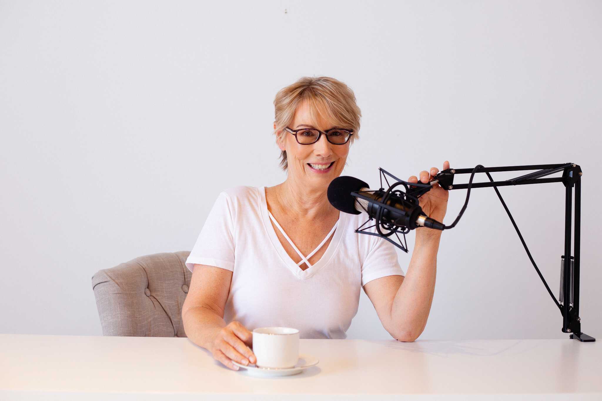Kelly Howard recording a podcast with purpose and passion while drinking a cup of coffee.