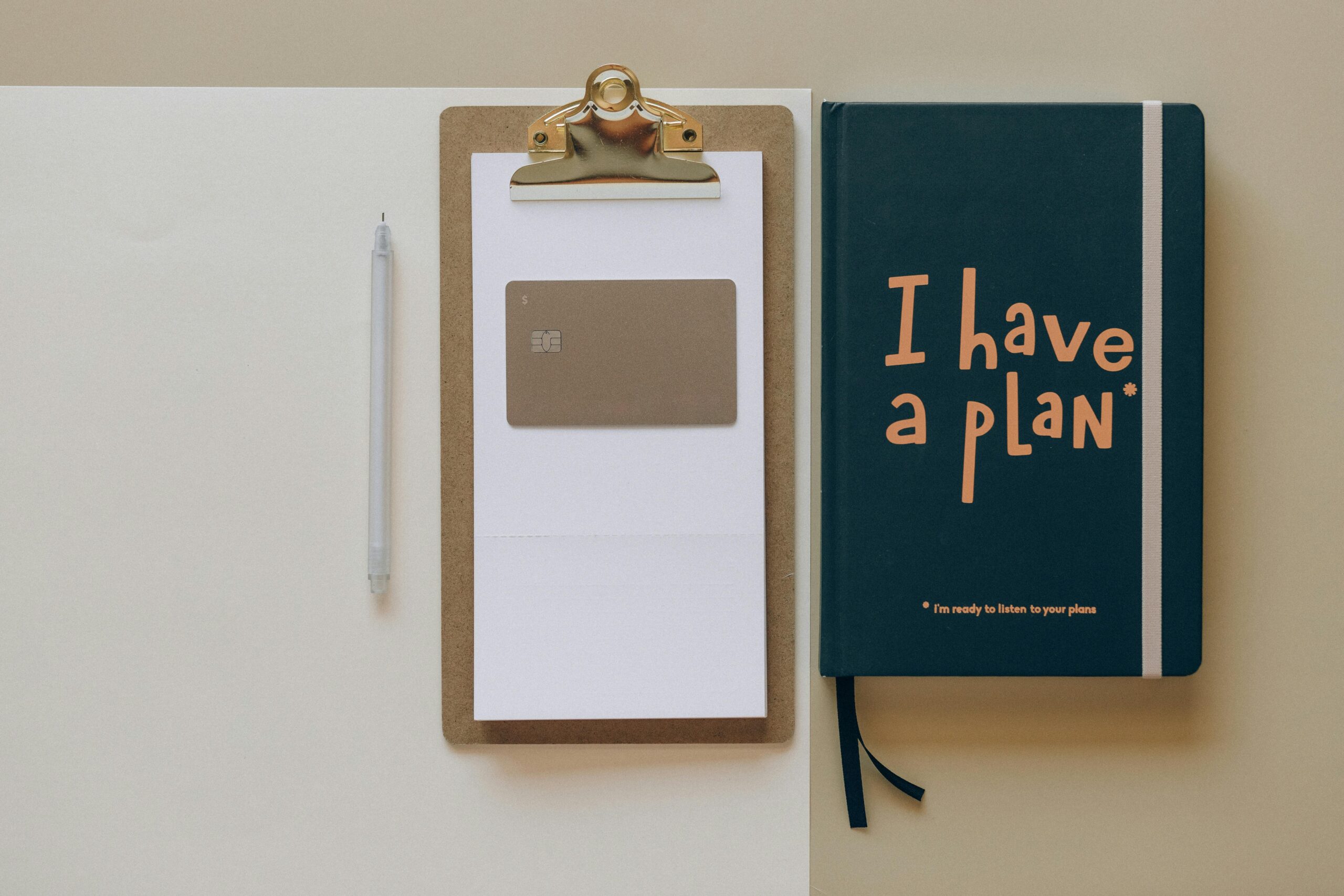 A pen, a clipboard with paper, a card, and a green notebook with "I have a plan!" written on the cover are arranged neatly on a surface—reminding one of vulnerabilities and limits in midlife.